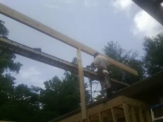 Carpenter setting a ridge beam over a new addition frame — Ice Dam Removal by Roofing Brothers in Vauxhall
