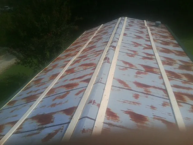 Rusted metal roof panels with new wood purlins before replacement — Storm Damage Roof Repair in Vauxhall by Roofing Brothers