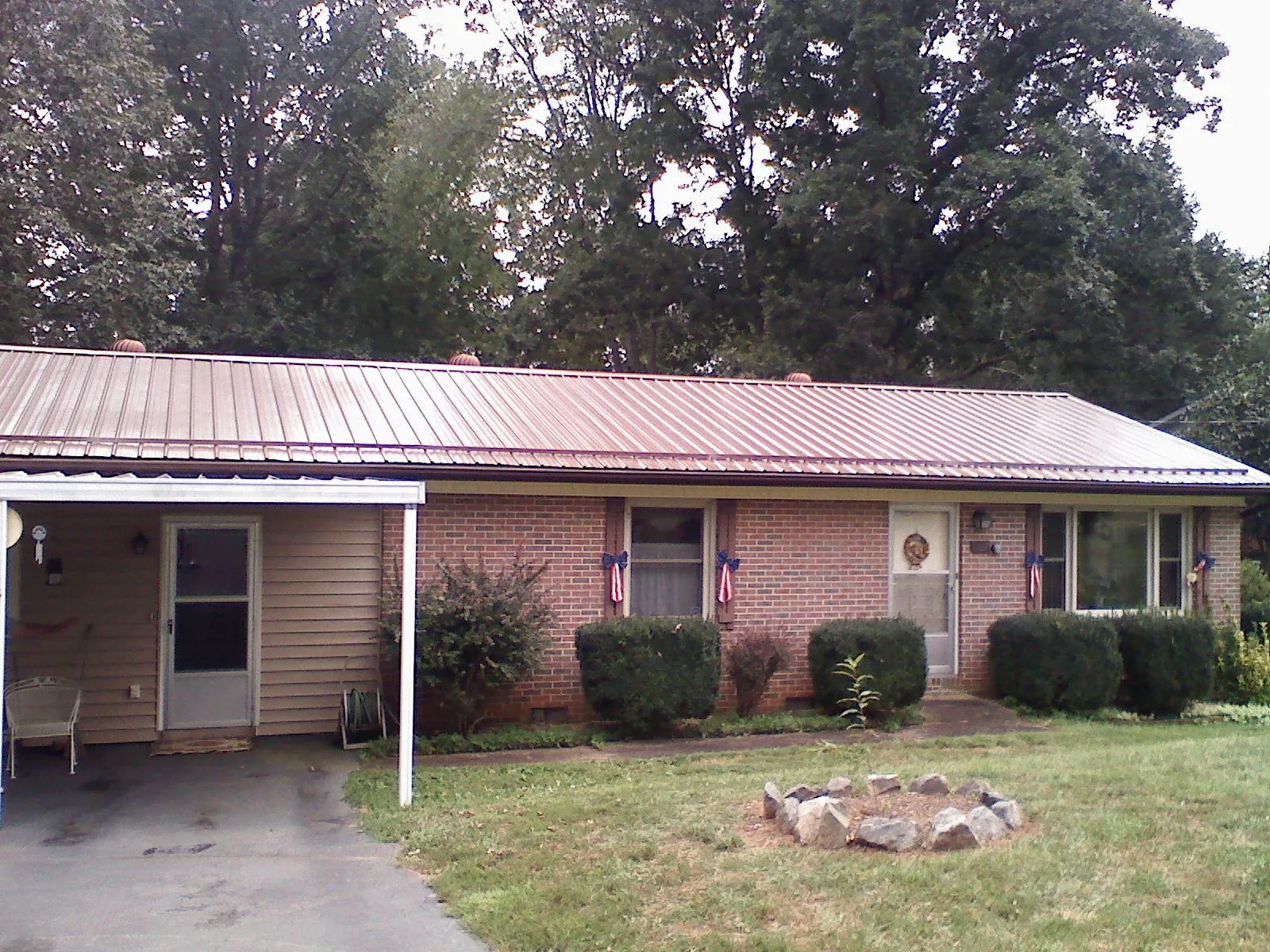 Bronze metal roof and carport on a brick ranch home — Roof Repair work by our crew in Vauxhall